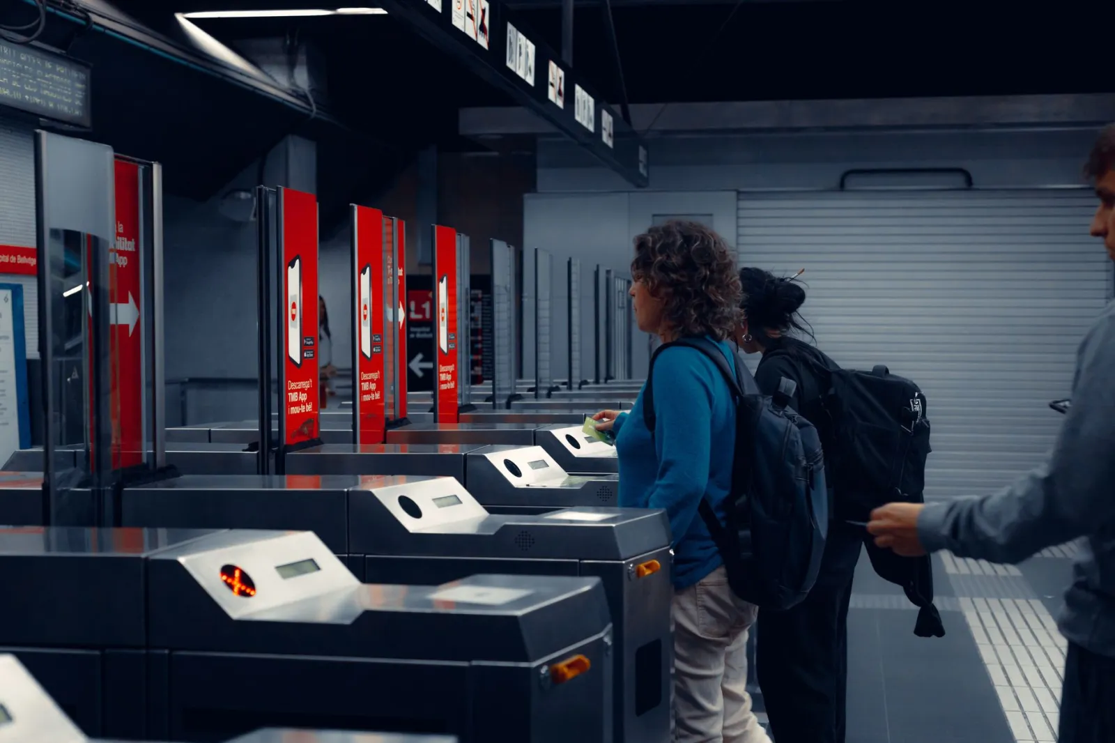 Urban commuters using turnstiles at a modern subway station, showcasing daily public transportation routine.